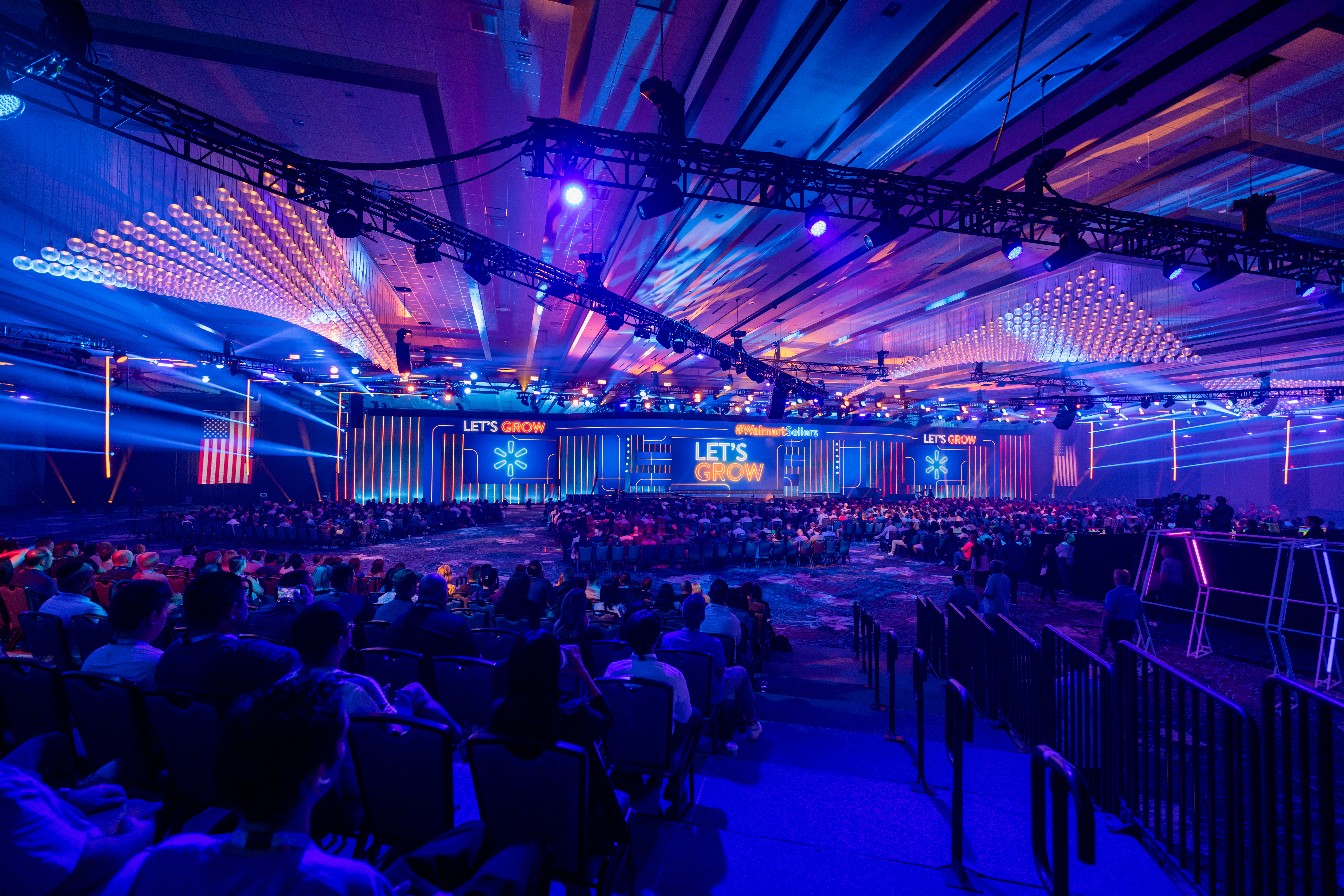 Professionally lit conference stage with attendees in foreground
